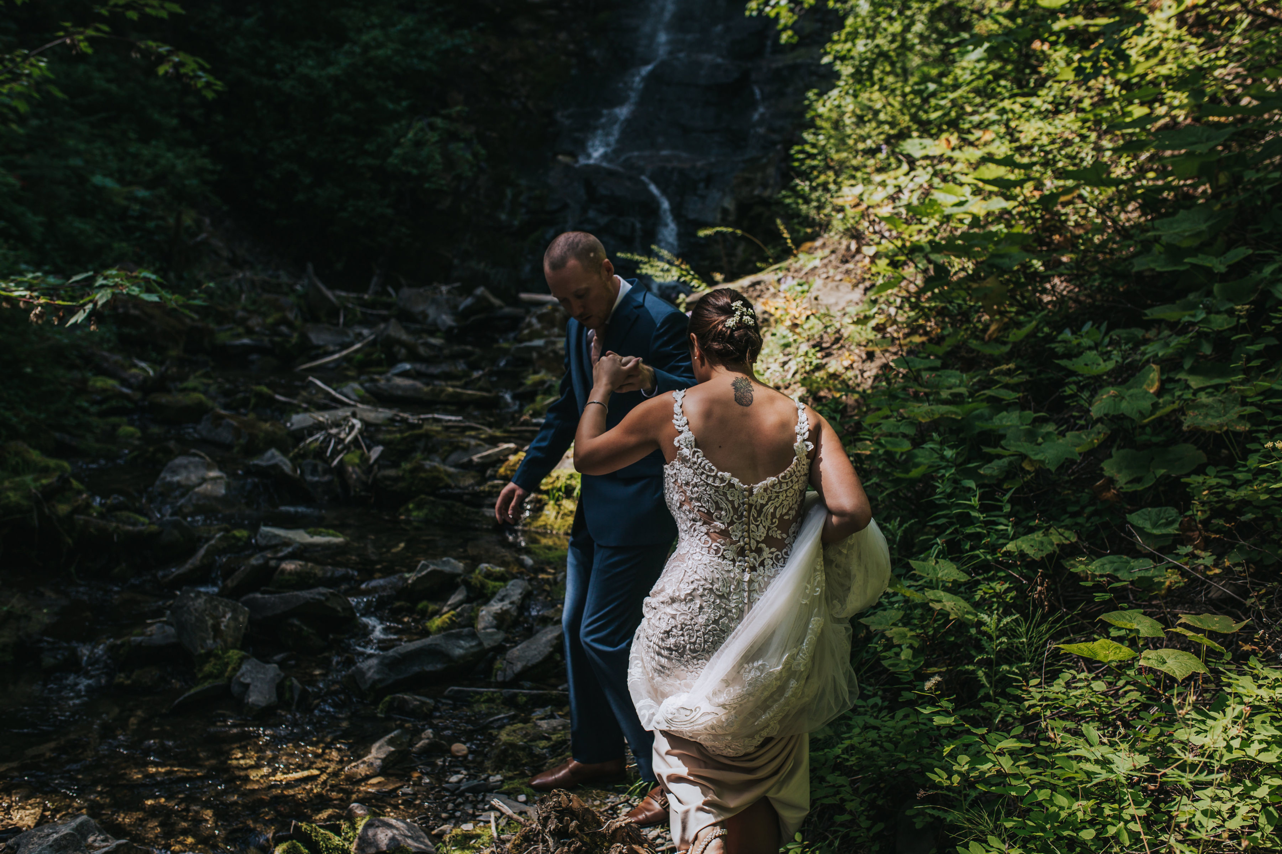 Bride and Groom walking towards waterfall