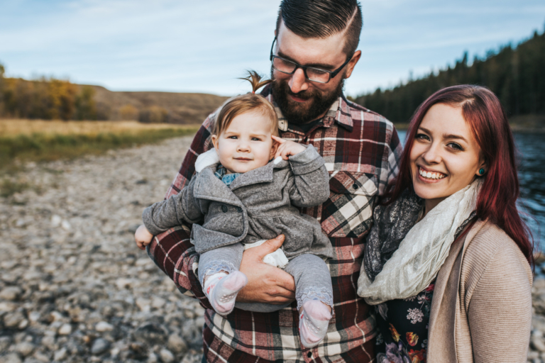 Couple holding little girl by a river