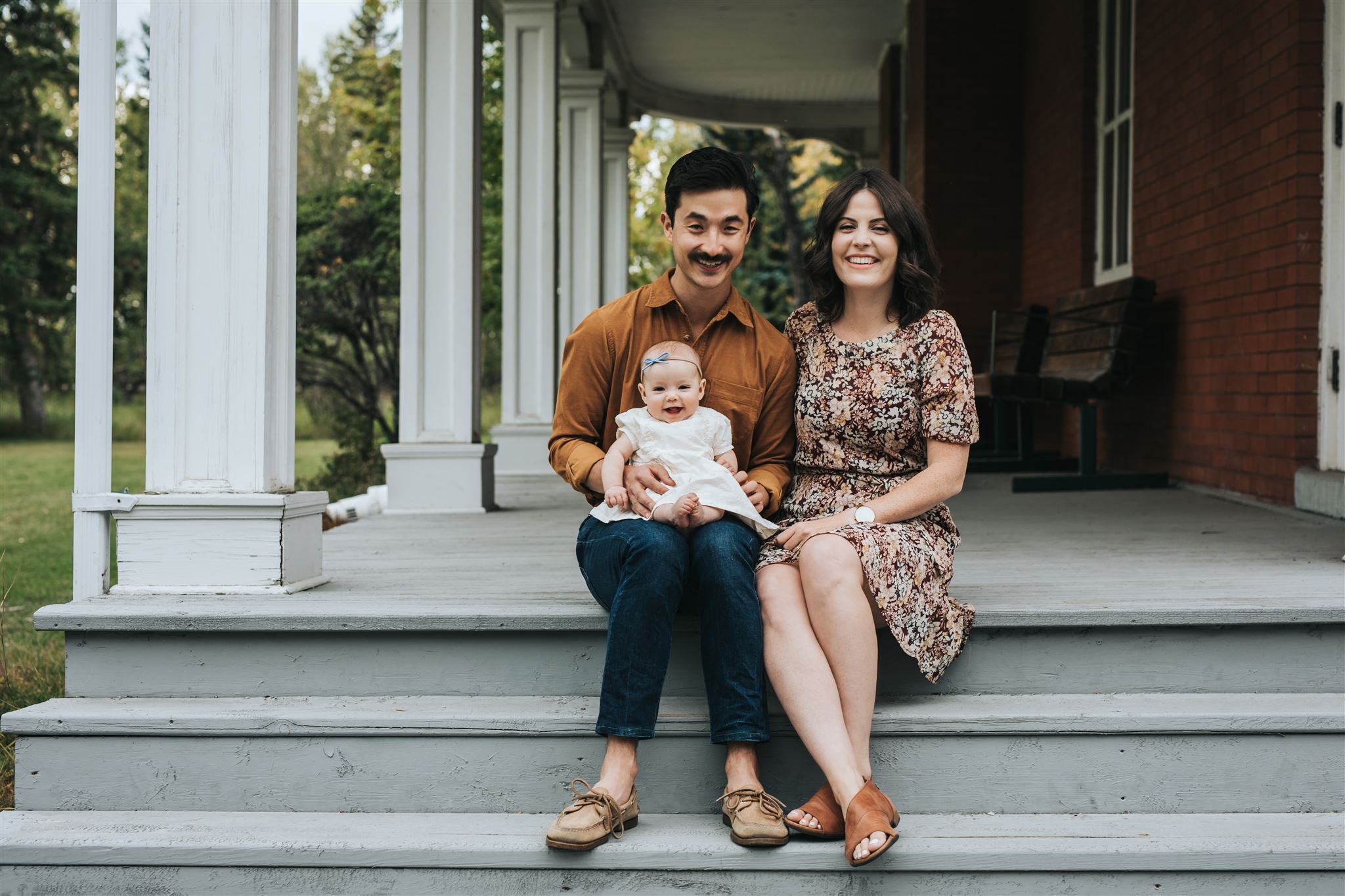 Family with newborn baby girl sitting on steps