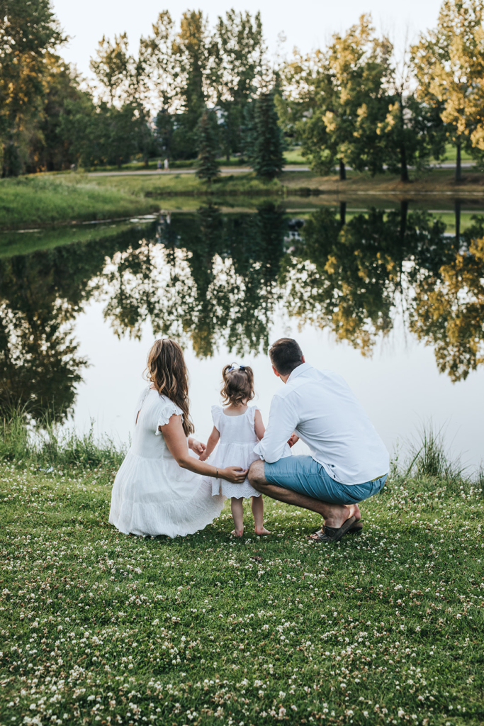 Family of three overlooking pond during maternity family session