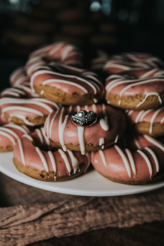 Wedding rings on stack of pink donuts