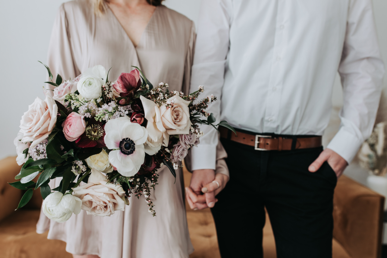 bride and groom holding hands and wedding bouquet