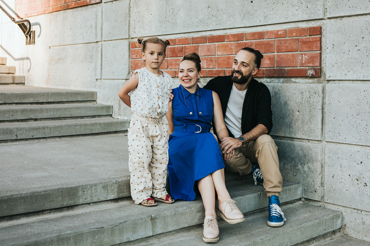 Family of three sitting on stairs in Bridgeland Calgary for their family photography session