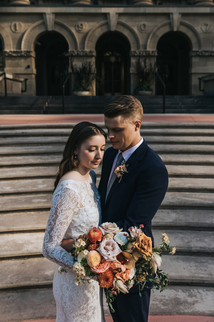 Calgary wedding photographer capturing a couple on their wedding day in downtown Calgary with bride holding a stunning colourful bouquet